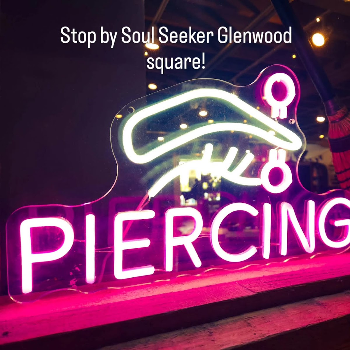 The pink neon piercing sign glowing in the Soul Seeker window