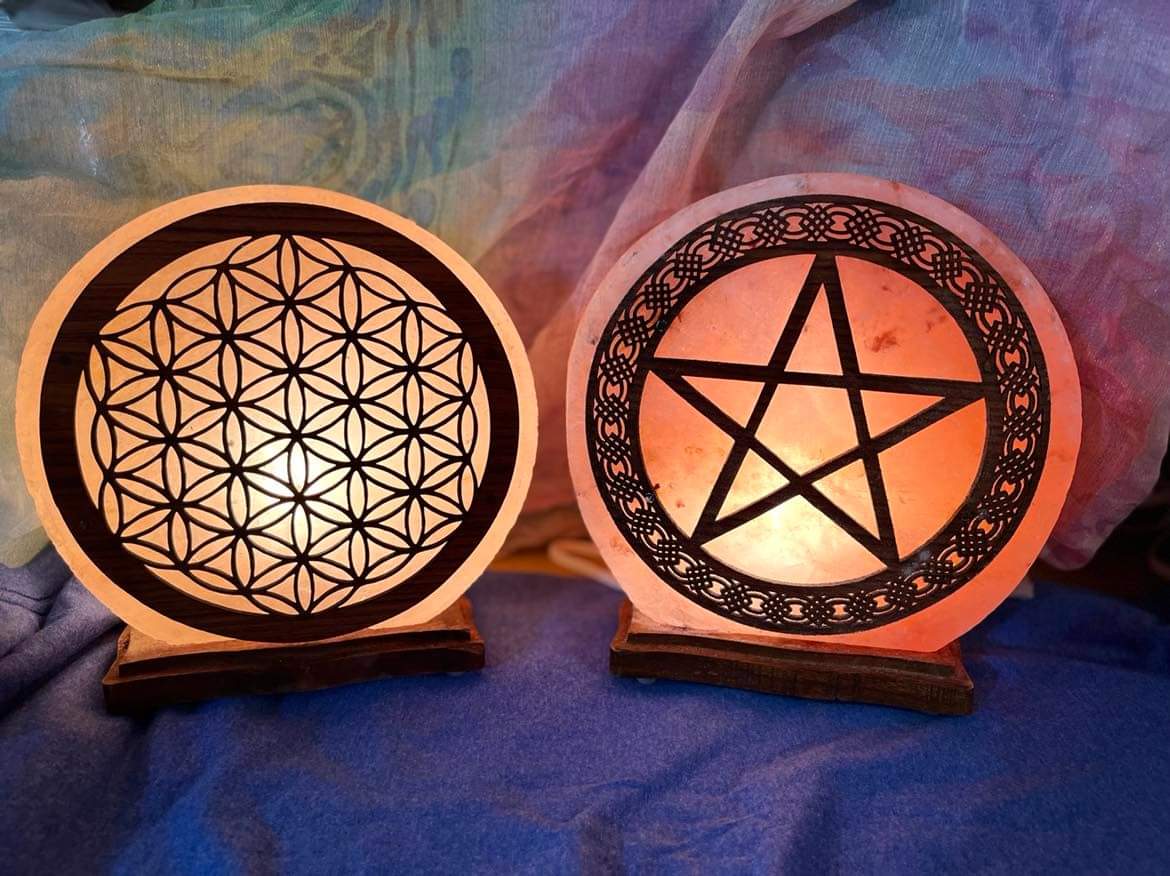 Himalayan salt lamps carved with the Flower of Life and a pentacle, glowing warm