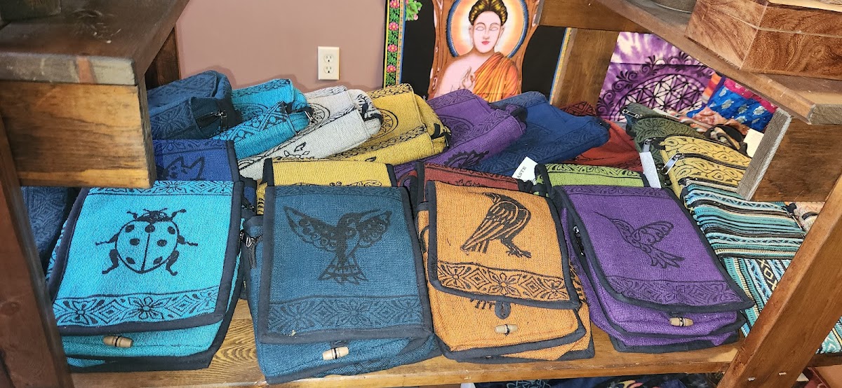 Shelf of woven bags with animal prints below a Buddha tapestry